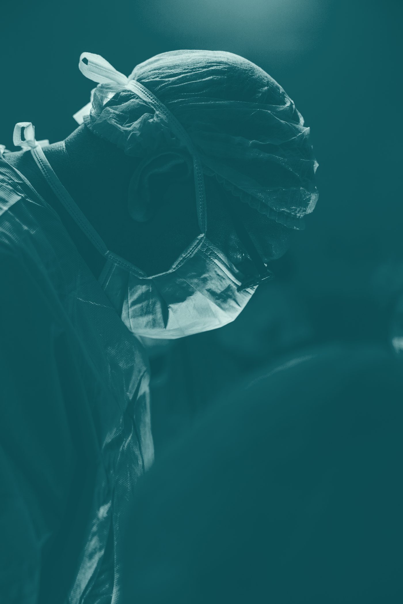 Teal-toned portrait of a veterinary internal-medicine specialist in a clinical setting